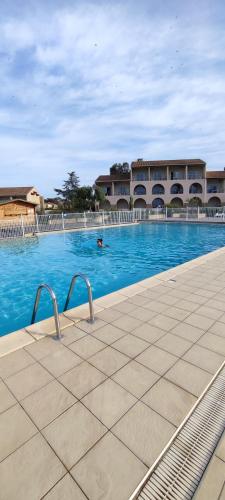 une personne nageant dans une grande piscine dans l'établissement Appartement T2 bord de mer Corse, à Linguizzetta