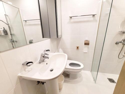 a white bathroom with a sink and a toilet at Incheon Airport Line Guesthouse in Incheon