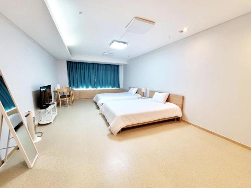 a hospital room with two beds and a television at Incheon Airport Line Guesthouse in Incheon