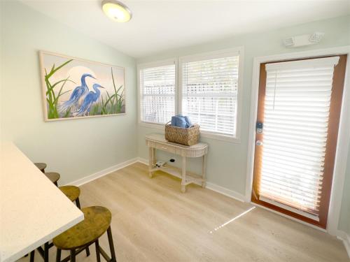 een woonkamer met een tafel en 2 ramen bij Orange Blossom Suite Conch Republic Cottage in Key West