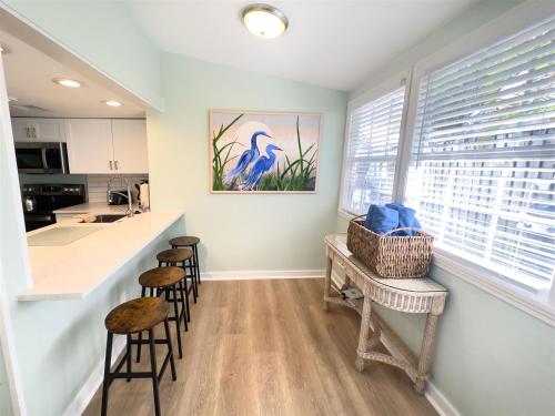 een keuken met krukken en een aanrecht met een aanrecht bij Orange Blossom Suite Conch Republic Cottage in Key West