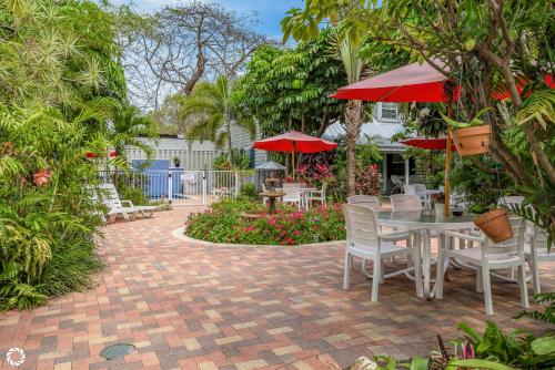a patio with a table and chairs and red umbrellas at Bonaire Suite in Key West