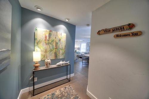 a hallway with a painting on the wall and a table with a lamp at Villa Serena Duval Square in Key West