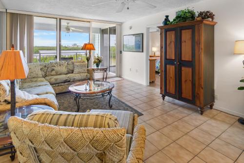 Una sala de estar con un sofá y sillas y una mesa. en La Brisa 303W, en Key West