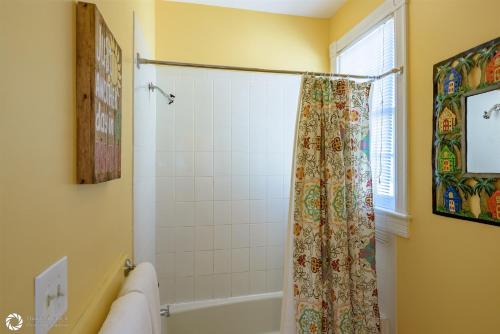 a bathroom with a shower curtain and a tub at Cuban Paradise Cuban Club in Key West