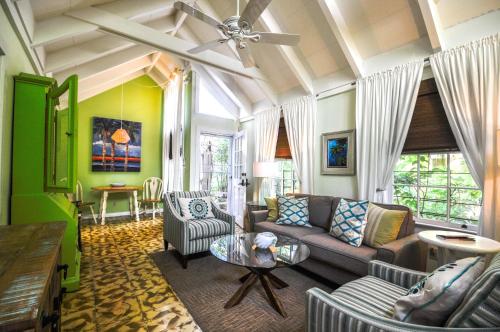 een woonkamer met een bank en een tafel bij Ann Street Cottage in Key West