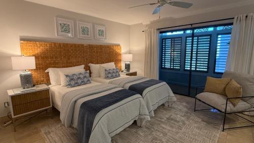 a bedroom with two beds and a chair at Glimmer Glass Kw Beach Club in Key West