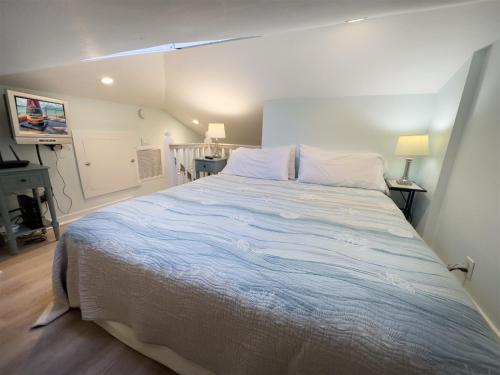 una camera da letto con un letto grande con lenzuola bianche di Conch Republic Cottage a Key West