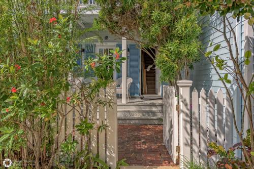 a white fence in front of a blue house at Parrotville in Key West