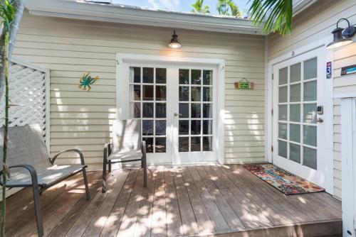 a patio with two chairs and a door at Sunset Suite Colony in Key West