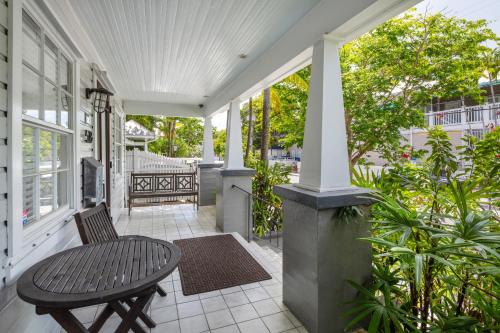 a porch with a table and a chair at Casa De Cuba in Key West