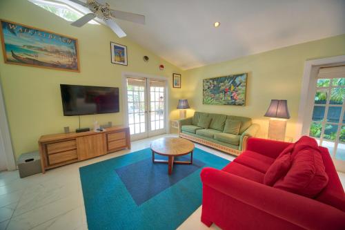a living room with a red couch and a tv at South St Cottage in Key West