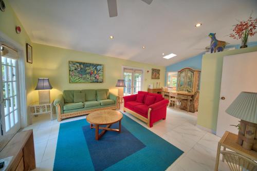 a living room with two couches and a table at South St Cottage in Key West