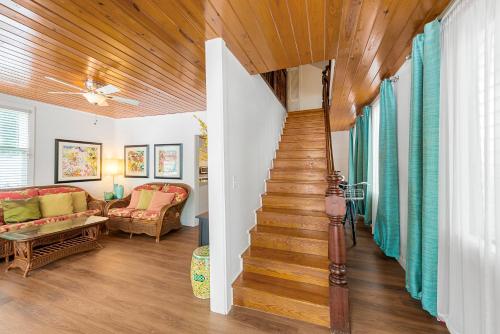 a staircase in a living room with wooden ceilings at Escape On Fleming in Key West