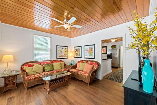 a living room with two couches and a ceiling fan at Escape On Fleming in Key West