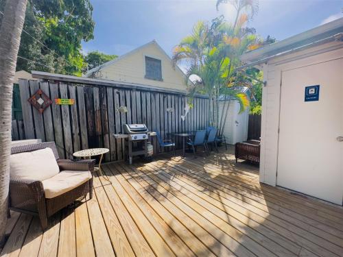 a deck with chairs and a table and a fence at Deckside Suite Conch Republic Cottage in Key West