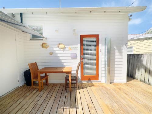 a wooden table and two chairs on a deck at Deckside Suite Conch Republic Cottage in Key West