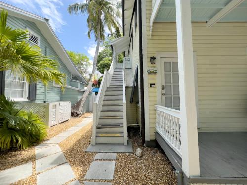 a house with a staircase leading to the front door at Utopia Tropical Village in Key West