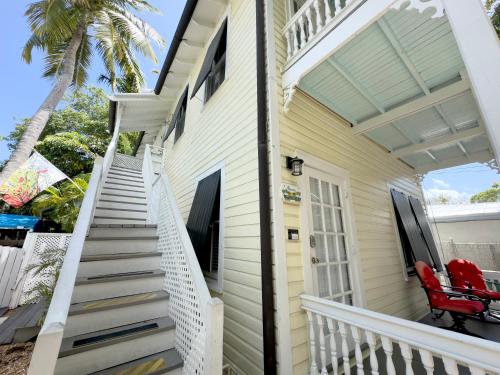 a front porch of a house with a red chair at Utopia Tropical Village in Key West