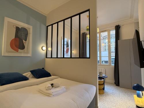 a bedroom with two beds and a mirror at Charming flat - 4 guests - 5 min from Metro and Canal in Pantin