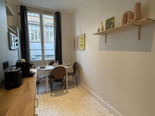 une salle à manger avec une table et des chaises et une fenêtre dans l'établissement Charming flat - 5 min from Metro and Canal, à Pantin
