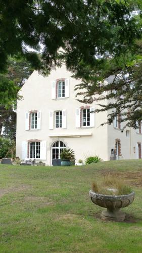 Une grande maison blanche avec un bol en pierre dans l'herbe dans l'établissement Maison familiale en bord de mer, à Arzon