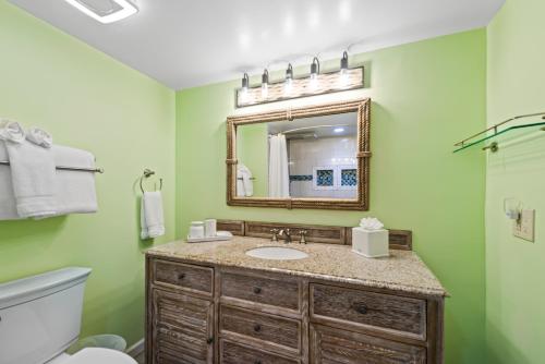 a bathroom with a sink and a mirror at Beach Club Oasis 304 in Key West