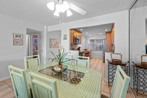 a dining room with a glass table and chairs at Sea Orchid La Brisa 405E in Key West
