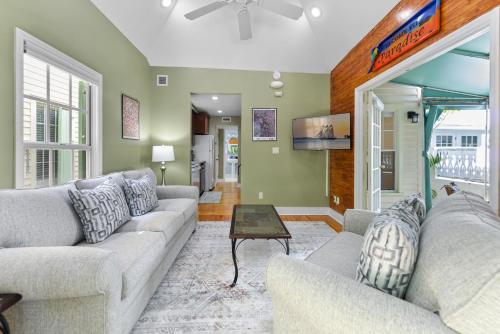 a living room with two couches and a table at Poolside Hide-Away Palm Gardens in Key West