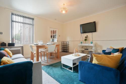 a living room with blue furniture and a dining room at HILLTOP PLACE SUITES 4 Bedrooms 6 BEDS for CONTRACTORS near M1J31 FREE PARKING FOR VANS in Killamarsh