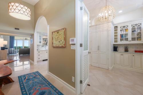 une grande cuisine avec des placards blancs et un couloir dans l'établissement Beach Club Paradise Penthouse 401, à Key West