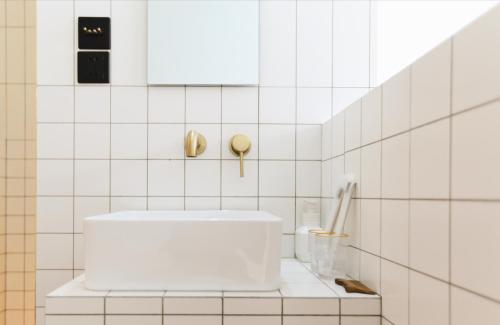 a white tiled bathroom with a white sink at YiXi Designer Hotel - Xi'an Bell Tower & Ming City Wall & T'ang Dynasty Ever-Bright City in Xi'an