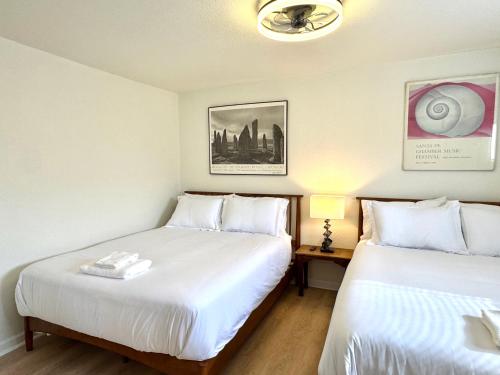 two beds in a room with white sheets at 2br Townhouse Taft Stadium & Plaza Dining #n39 in Oklahoma City
