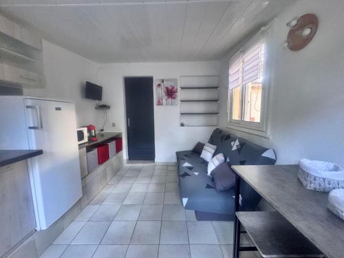un salon avec un canapé bleu dans une cuisine dans l'établissement Les pieds dans l'eau T2 E, à Calvi