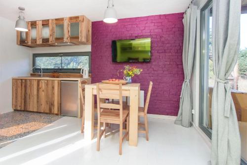 a kitchen with a table and a purple wall at SOBIESZEPTY Odetchnij ciszą in Gdańsk