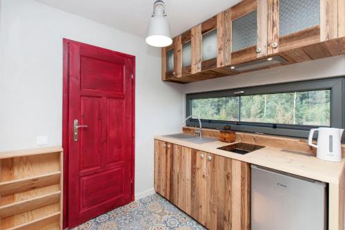a kitchen with a red door and a counter at SOBIESZEPTY Odetchnij ciszą in Gdańsk