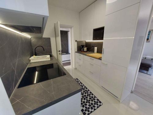 eine große Küche mit weißen Schränken und einem Waschbecken in der Unterkunft Apartment in Malinska 50 in Malinska