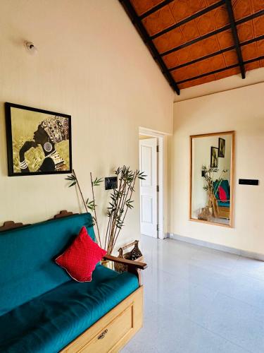 a living room with a blue couch in a room at The Home Resort - Coorg in Kakkabe