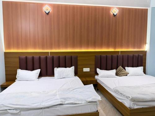 two beds are in a room with a wall at Maa durga home stay in Faizābād