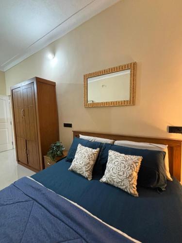 a bedroom with a blue bed with two pillows at The Home Resort - Coorg in Kakkabe