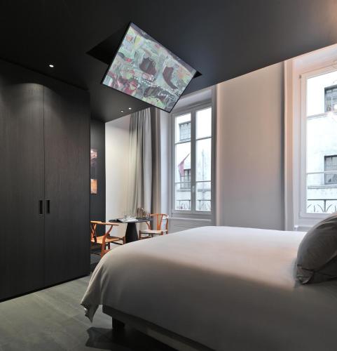 une chambre avec un lit blanc et une table dans l'établissement mmm - 25BA - Suites de Luxe - Centre de Lyon, à Lyon