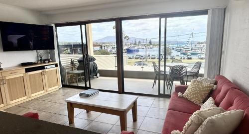 a living room with a couch and a tv and a table at Views, location & luxury in the heart of Bermi! Walking distance to everything in Bermagui