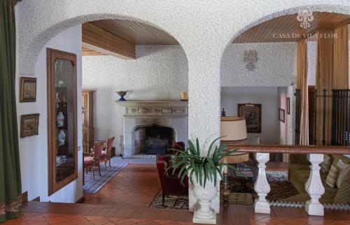 a living room with a fireplace and a table at Casa de Vila Flor in Grijó