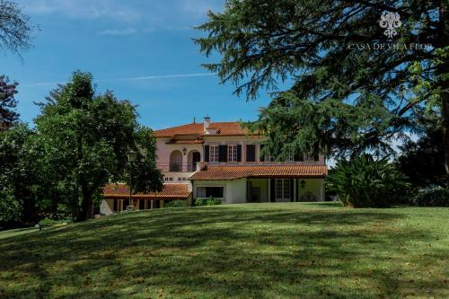 a house on a hill with a large yard at Casa de Vila Flor in Grijó