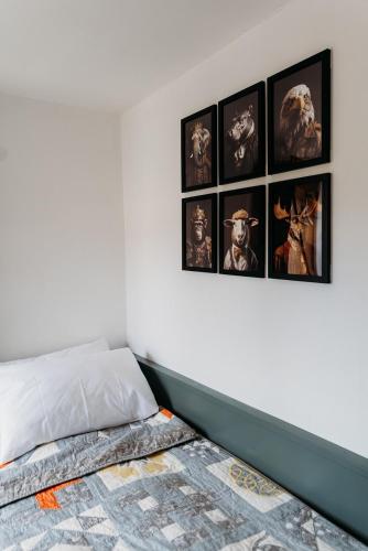 a bedroom with a bed with pictures on the wall at Stunning 2BD in the Heart of Malmesbury! in Malmesbury