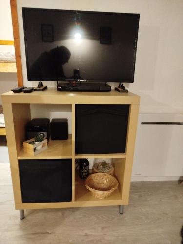 a television on top of a wooden tv stand at Superbe appartement à Valfréjus in Valfréjus