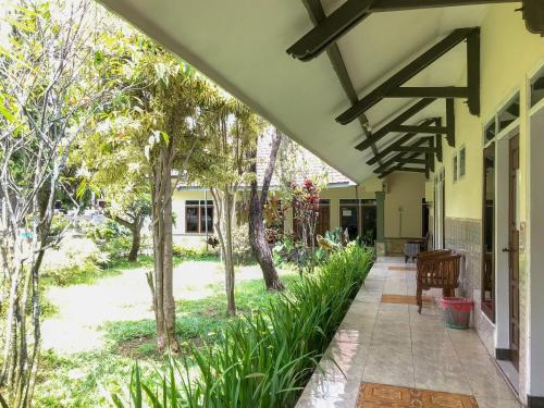 a porch of a house with trees and plants at Villa Bunga Guest House RedPartner in Malang