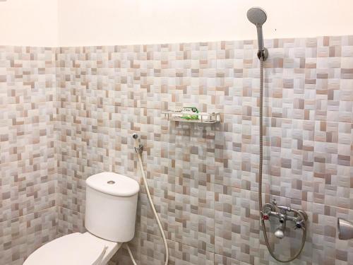 a bathroom with a shower with a toilet in it at Villa Bunga Guest House RedPartner in Malang