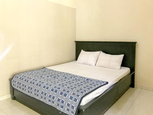 a small bedroom with a bed with white sheets at Villa Bunga Guest House RedPartner in Malang