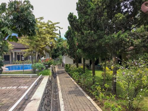 a garden in front of a house at Villa Bunga Guest House RedPartner in Malang
